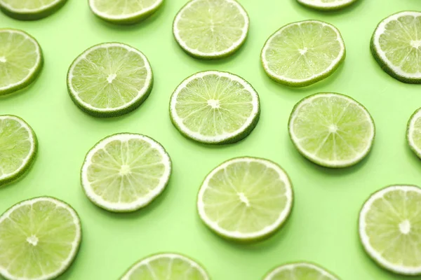 Slices of fresh juicy limes on green background