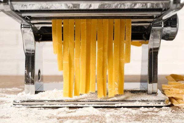 Pasta maker machine with dough on table, closeup — Stock Photo, Image
