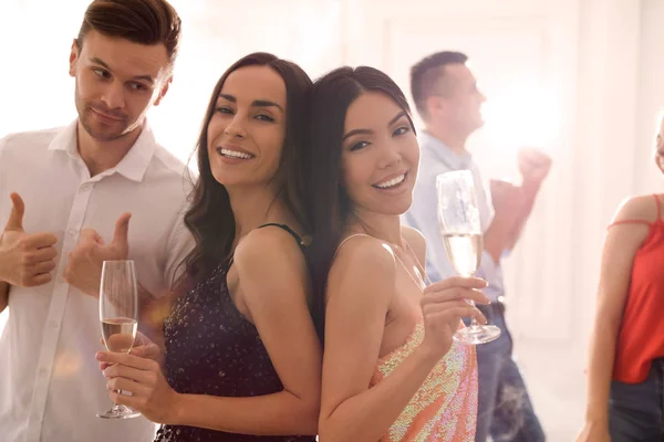 Пара щасливих друзів з шампанським танцює на вечірці — стокове фото