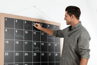 Takvimde tebeşirle yazı yazan yakışıklı adam.