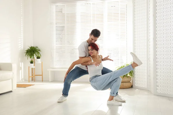 Bella giovane coppia che balla in soggiorno — Foto Stock