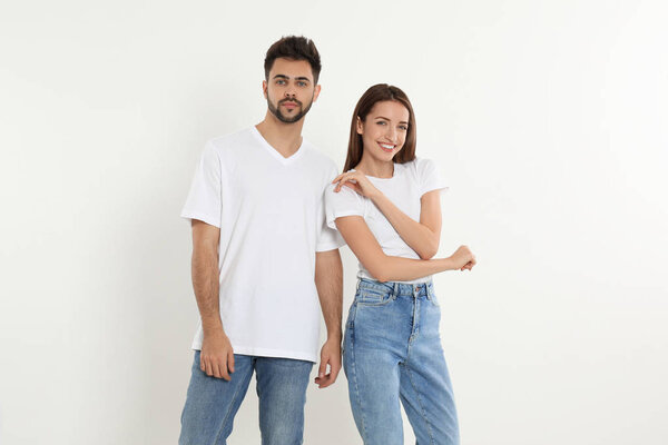 Young couple in stylish jeans on white background