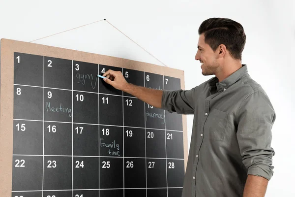 Snygg man skriver med krita ombord kalender — Stockfoto