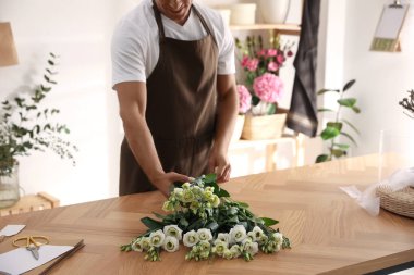 Çiçekçi atölyede güzel buket yapıyor, yakın plan.