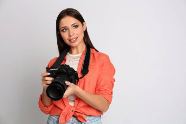 Stüdyoda beyaz arka plan üzerinde çalışan profesyonel fotoğrafçı.