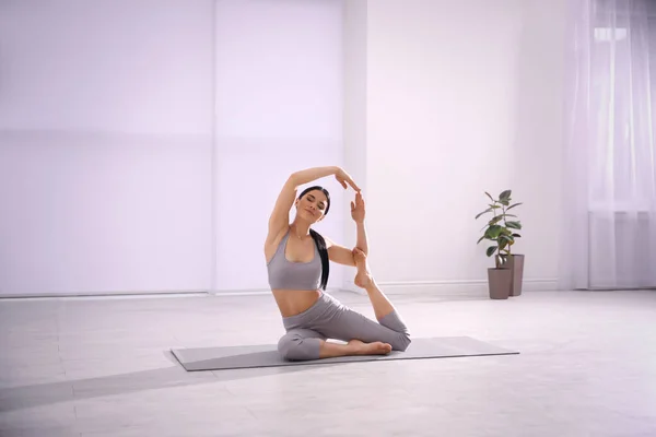 Junge Frau praktiziert im Yoga-Studio Asana der Meerjungfrau. eka pada ra — Stockfoto