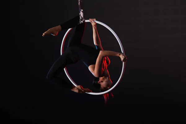 Mujer joven realizando elemento acrobático en anillo aéreo contra —  Fotos de Stock