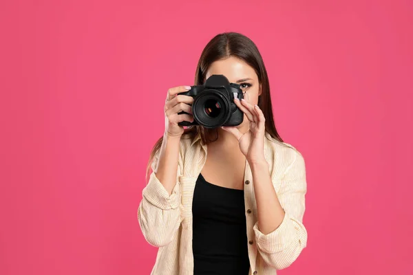 Fotógrafo profissional trabalhando em fundo rosa em estúdio — Fotografia de Stock
