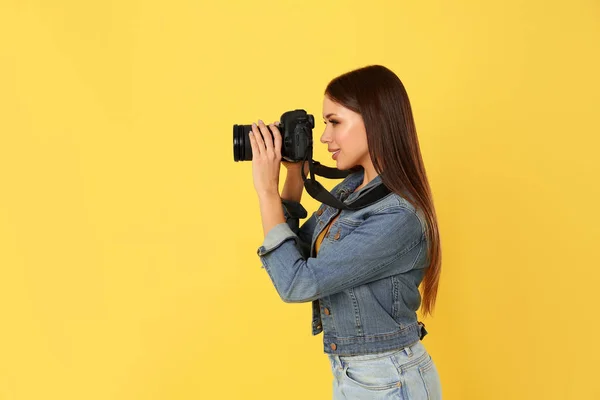 Fotógrafo profissional trabalhando em fundo amarelo em estúdio — Fotografia de Stock