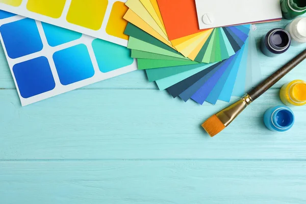 Плоска композиція з кольоровими палітрами на світло-блакитній дерев'яній ба — стокове фото