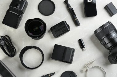 Gri mermer masa üzerinde profesyonel fotoğrafçı için ekipmanla düz kompozisyon