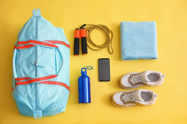 Gymtas, smartphone en sportuitrusting op gele achtergrond, f — Stockfoto