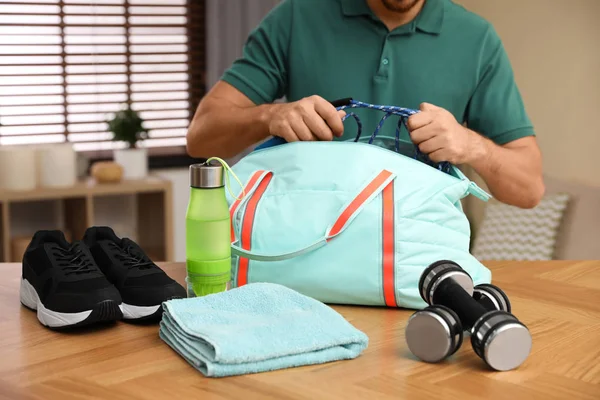 Мужчина упаковывает спортивную сумку для тренировок в помещении, крупным планом — стоковое фото