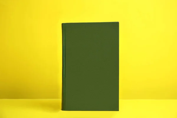 Libro con copertina rigida su sfondo giallo. Spazio per il design — Foto Stock