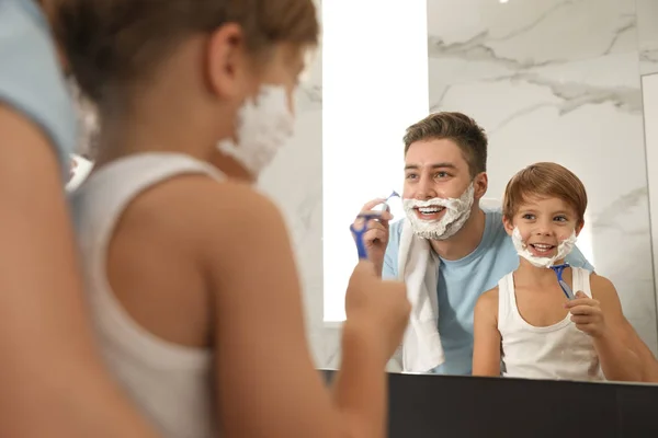 Papa scheren en zoon imiteren hem in de badkamer — Stockfoto