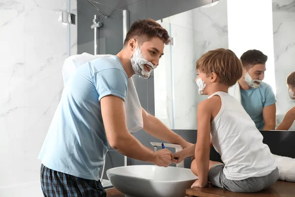 Ο μπαμπάς και ο γιος πλένουν ξυράφια στο μπάνιο. — Φωτογραφία Αρχείου