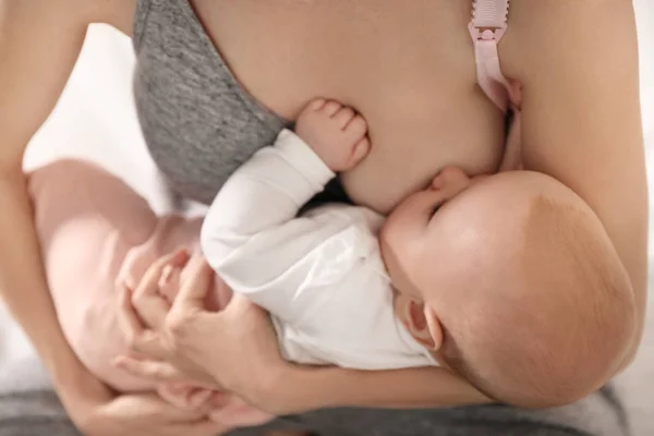 Молода жінка грудей годує свою маленьку дитину, крупним планом — стокове фото