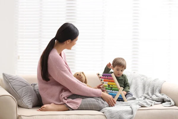 Junges Kindermädchen und süßes kleines Baby, das zu Hause mit Abakus spielt — Stockfoto