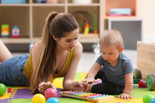 Teenie-Kindermädchen und süßes kleines Baby spielen zu Hause mit Xylophon — Stockfoto