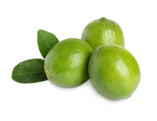 Limes freschi maturi con foglie verdi isolate su bianco — Foto Stock