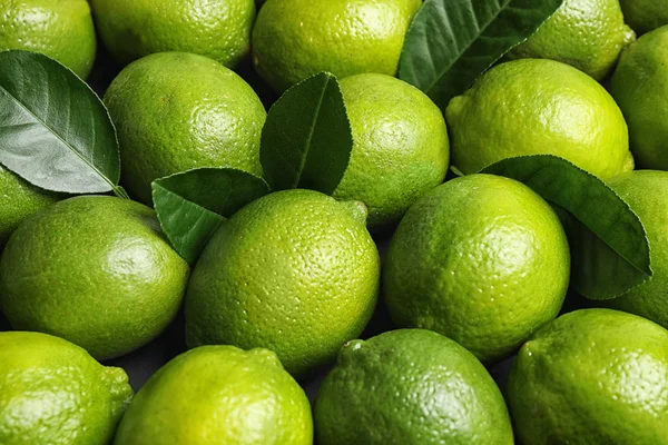 Färska mogna saftiga lime som bakgrund, närbild — Stockfoto