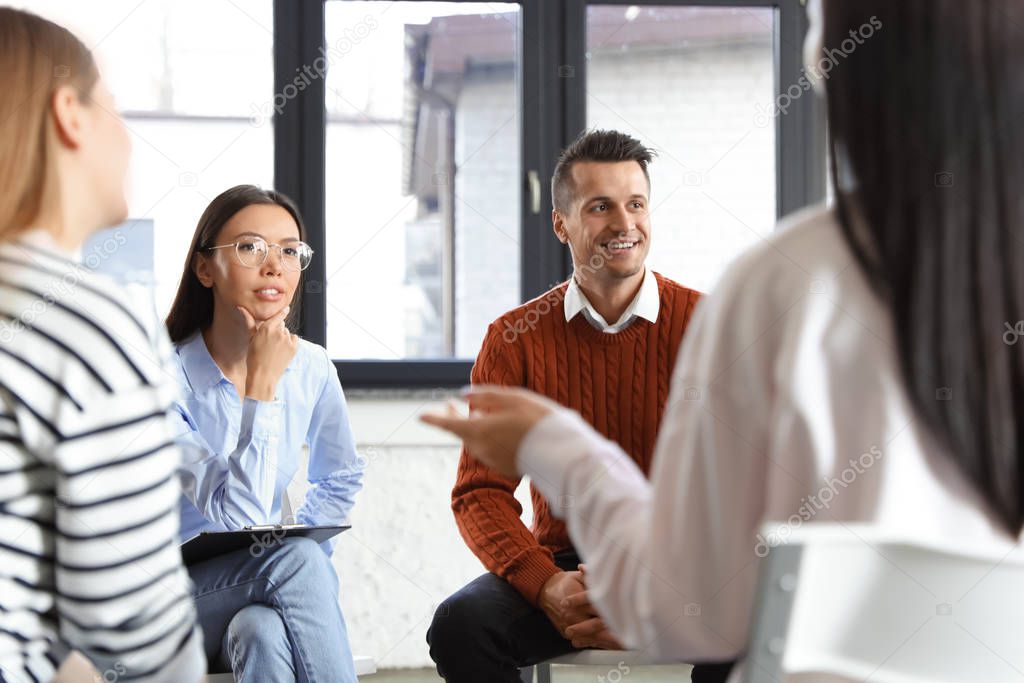Psychotherapist working with patients in group therapy session indoors