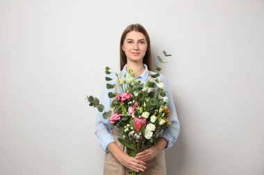 Açık arkaplanda güzel buketi olan bir çiçekçi.