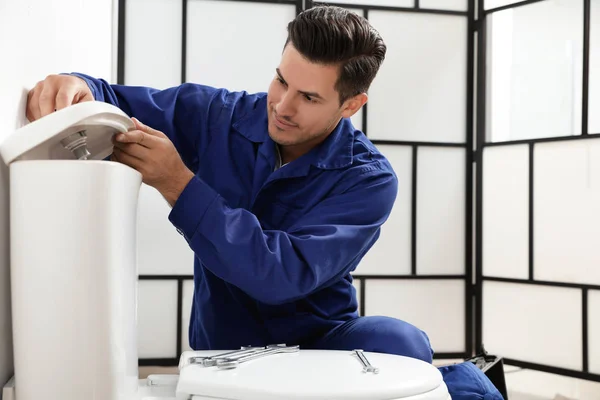 Professionele loodgieter werken met toilet kom in de badkamer — Stockfoto