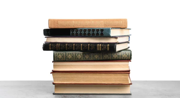 Pila de viejos libros antiguos sobre mesa de piedra contra fondo blanco —  Fotos de Stock