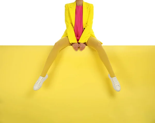 Kvinna bär gula strumpbyxor och snygga skor sitter på färg b — Stockfoto