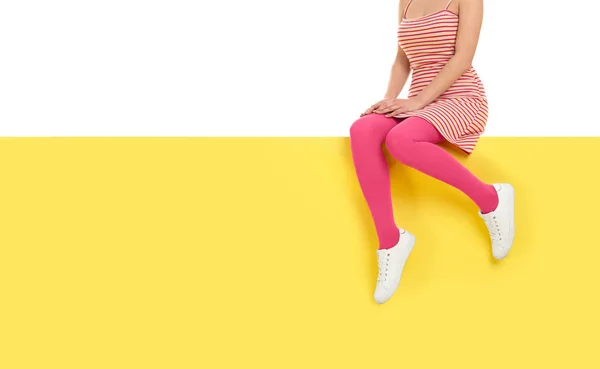 분홍색 스타킹을 입고 컬러 배경에 앉아 있는 여자, 클로즈업. — 스톡 사진