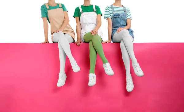 Группа женщин в красочных колготках и стильной обуви сидит — стоковое фото