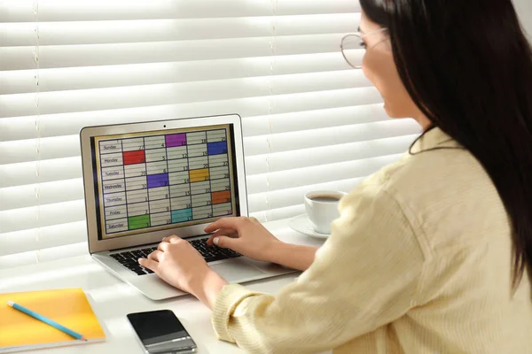 Mladá žena pomocí aplikace kalendář na notebooku v kanceláři — Stock fotografie