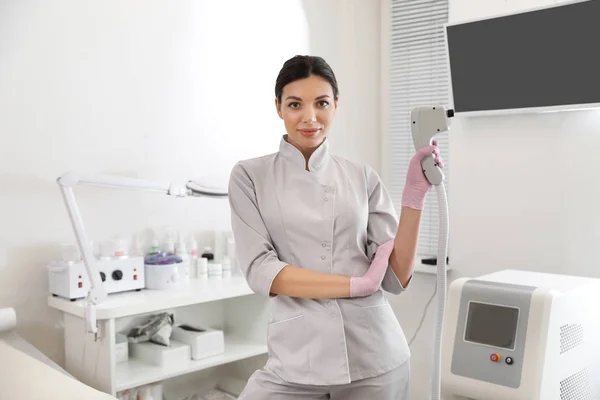 Jovem mulher segurando epilator laser profissional no salão de beleza — Fotografia de Stock