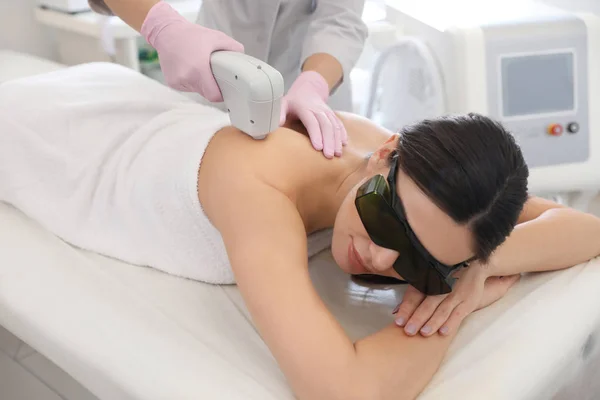 Mujer joven sometida a un procedimiento de depilación láser en el salón de belleza — Foto de Stock