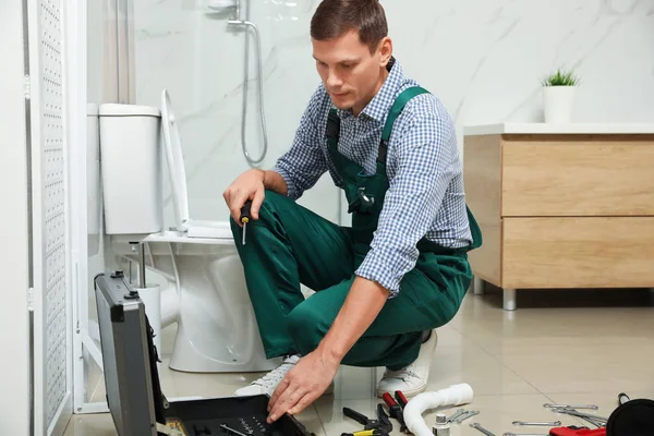 Fontanero profesional reparación de tanque de inodoro en el baño — Foto de Stock