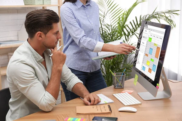 Collega 's werken met kalender app op computer in kantoor — Stockfoto