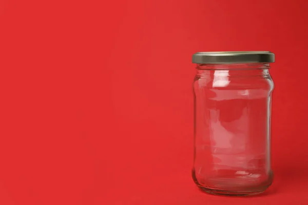 Frasco de vidro vazio fechado no fundo vermelho, espaço para texto — Fotografia de Stock
