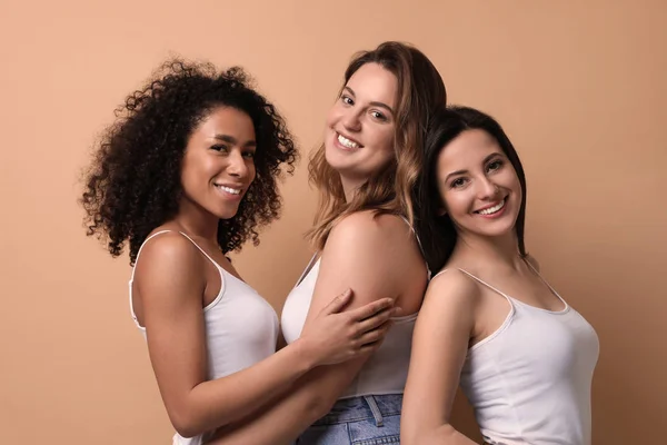 Group of women with different body types on beige background