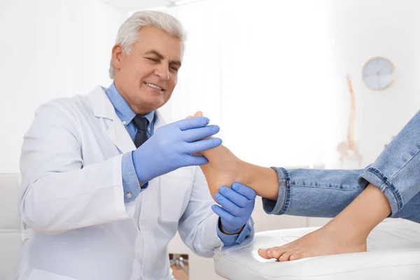 Male orthopedist checking patient's foot in clinic — Stock Photo, Image