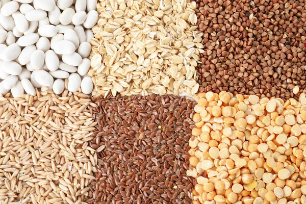 Different grains and cereals as background, top view — Stock Photo, Image