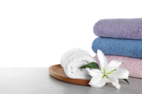 Fresh towels and lily flower on light grey marble table against — Stock Photo, Image