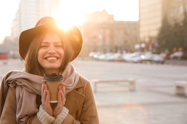 Sabahları elinde kahve olan genç bir kadın.