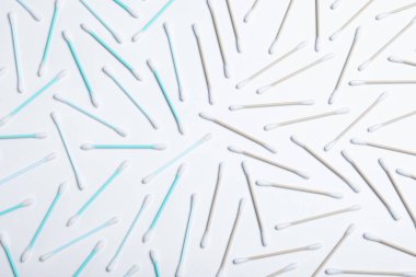 Beyaz arka planda plastik ve ahşap pamuklu çubuklar, üst manzara. Geri dönüşüm kavramı