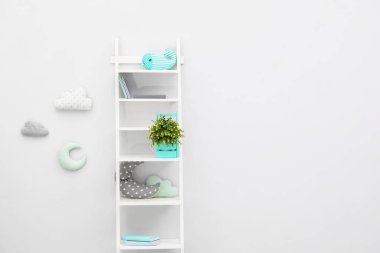 Çocuk odasındaki ışıklı duvarın yanında şık bir raf ünitesi