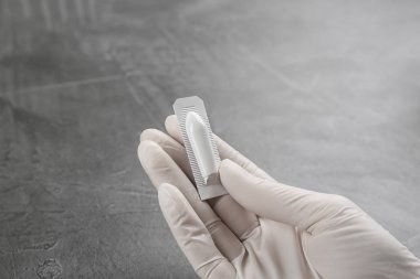 Gri masada fitil tutan kadın, yakın plan. Hemoroit tedavisi