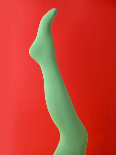 Beinpuppe Grünen Strumpfhosen Auf Rotem Hintergrund — Stockfoto