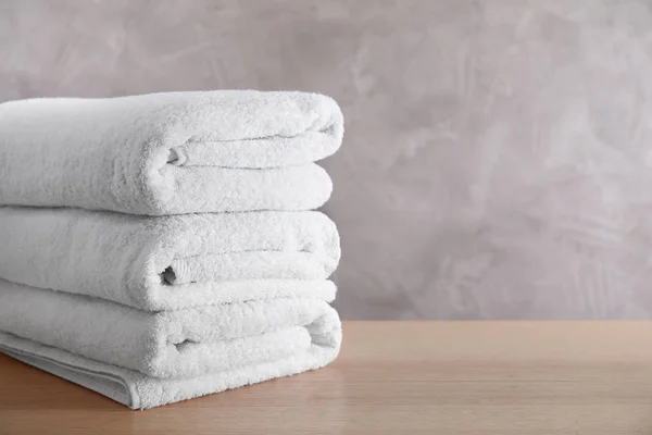 Stack of clean bath towels on wooden table. Space for text — Stock Photo, Image