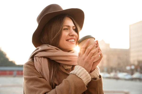 Mujer joven con taza de café en la calle de la ciudad por la mañana — Foto de Stock