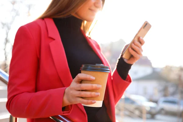 Empresária com xícara de café e smartphone na rua da cidade i — Fotografia de Stock